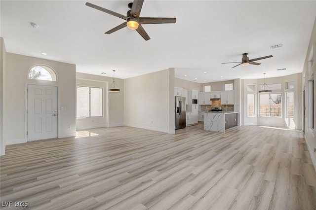 unfurnished living room with light wood finished floors, baseboards, visible vents, and recessed lighting