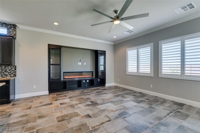 unfurnished living room featuring ornamental molding, a glass covered fireplace, and visible vents