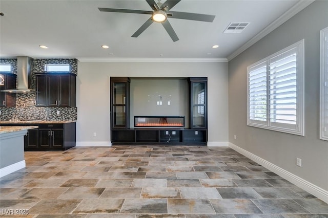 unfurnished living room featuring crown molding, recessed lighting, visible vents, a glass covered fireplace, and baseboards