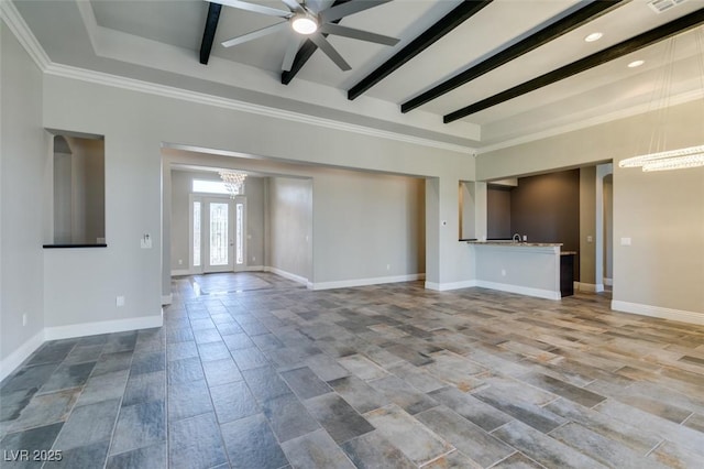 unfurnished living room featuring ceiling fan with notable chandelier, beamed ceiling, wood finished floors, and baseboards