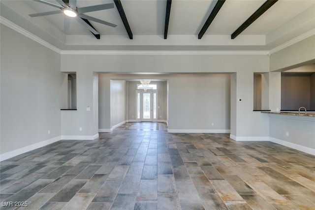 unfurnished living room featuring ceiling fan with notable chandelier, beamed ceiling, and baseboards