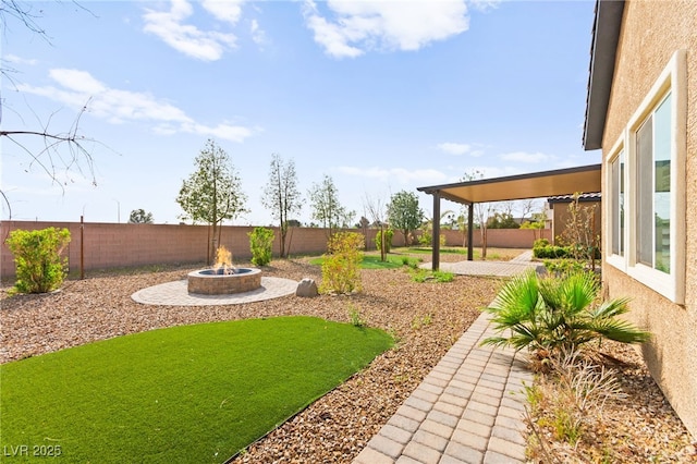 view of yard featuring a fenced backyard, an outdoor fire pit, and a patio