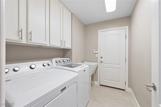 laundry room featuring baseboards, cabinet space, and washing machine and dryer