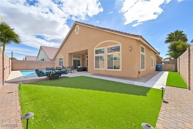 back of house with stucco siding, a tile roof, a fenced backyard, outdoor lounge area, and a patio area