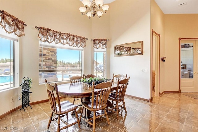 dining space featuring visible vents, a high ceiling, baseboards, and a notable chandelier