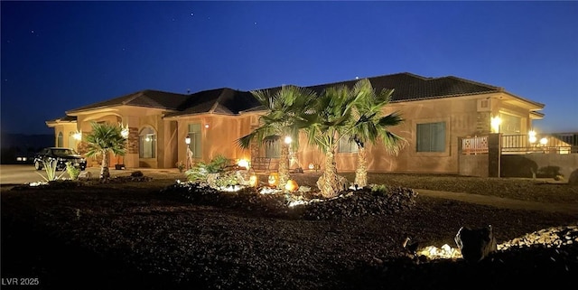 property exterior at twilight featuring stucco siding