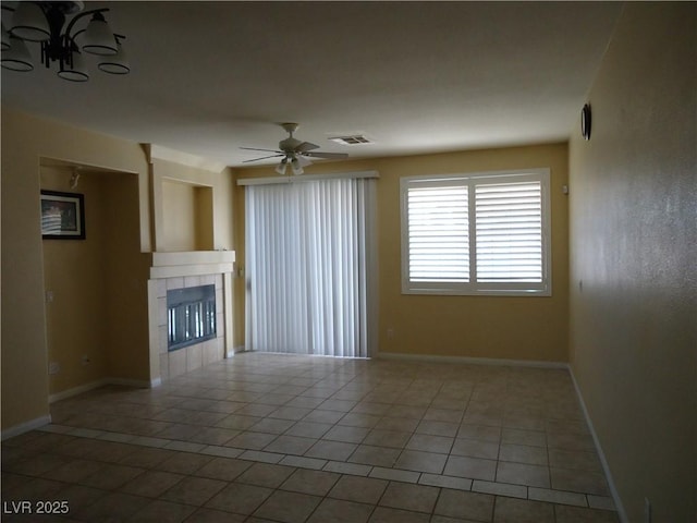 unfurnished living room featuring baseboards, visible vents, a tiled fireplace, ceiling fan, and tile patterned flooring