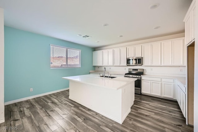 kitchen featuring appliances with stainless steel finishes, dark wood-style flooring, visible vents, and a sink