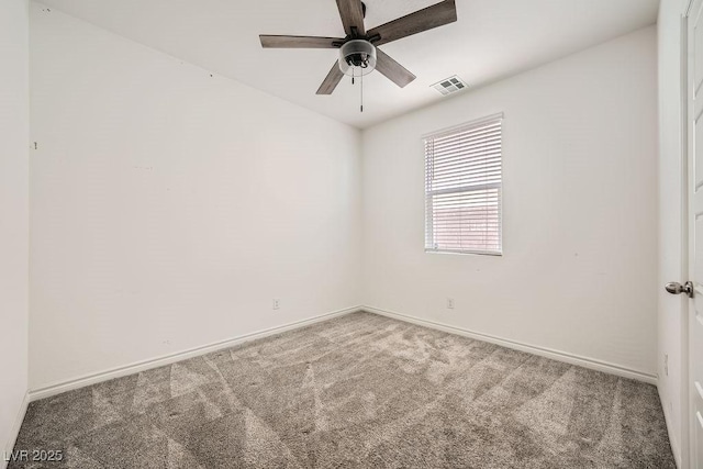 spare room featuring carpet floors, a ceiling fan, visible vents, and baseboards