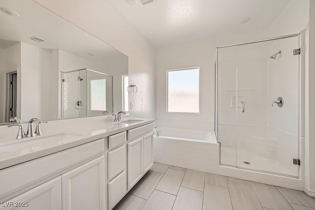 bathroom with a garden tub, a sink, a shower stall, and double vanity