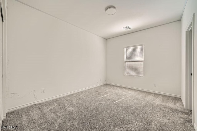 carpeted empty room featuring baseboards and visible vents