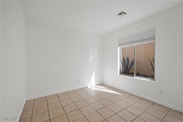 spare room with baseboards, visible vents, and light tile patterned flooring