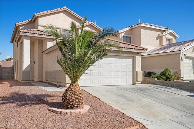 mediterranean / spanish house featuring driveway, an attached garage, a tile roof, and stucco siding