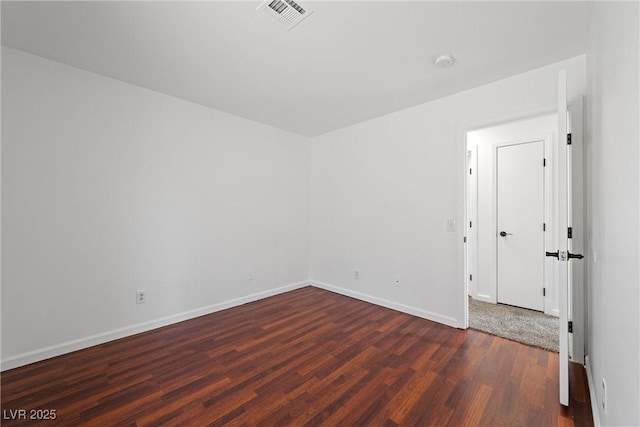 unfurnished room with visible vents, baseboards, and wood finished floors