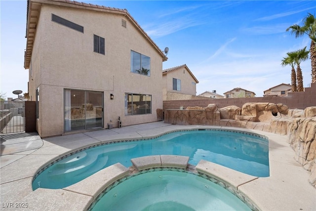 view of swimming pool with a pool with connected hot tub, fence, and a patio