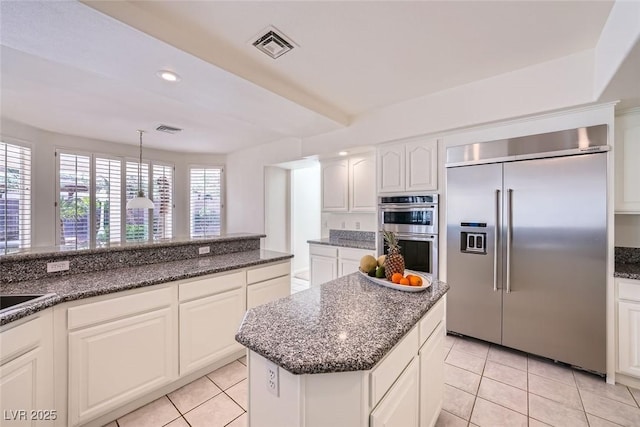 kitchen featuring white cabinets, light tile patterned floors, visible vents, and stainless steel appliances