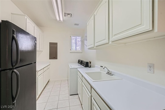 kitchen with electric panel, washer / clothes dryer, freestanding refrigerator, white cabinetry, and a sink