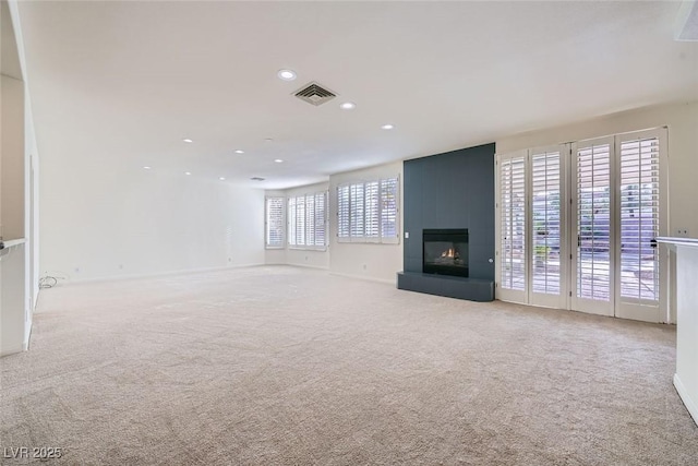 unfurnished living room with carpet, a fireplace, visible vents, and recessed lighting