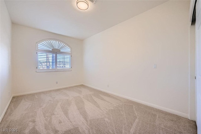 carpeted empty room featuring baseboards