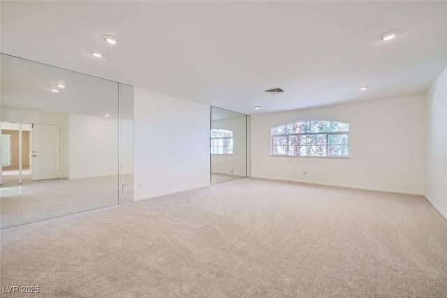 empty room with recessed lighting, visible vents, baseboards, and light colored carpet