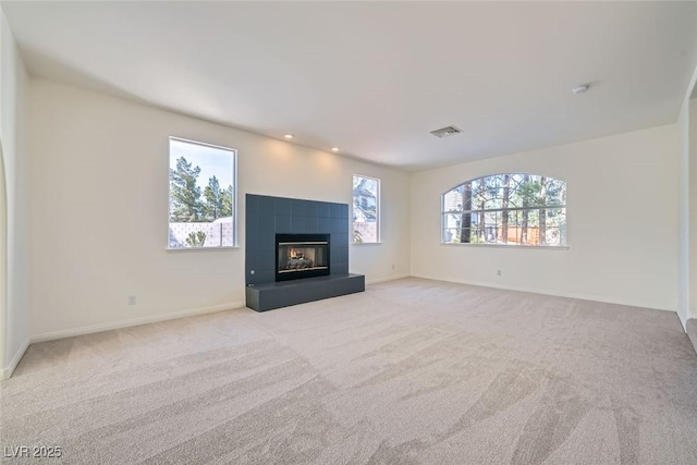 unfurnished living room featuring light carpet, baseboards, visible vents, a fireplace, and recessed lighting