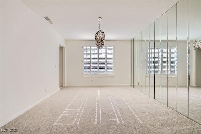 carpeted spare room with baseboards and visible vents