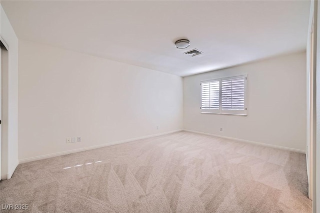 carpeted spare room featuring visible vents and baseboards