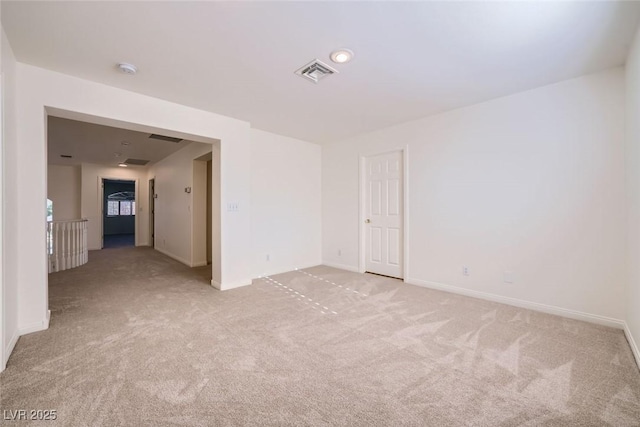 unfurnished room featuring light colored carpet, visible vents, and baseboards