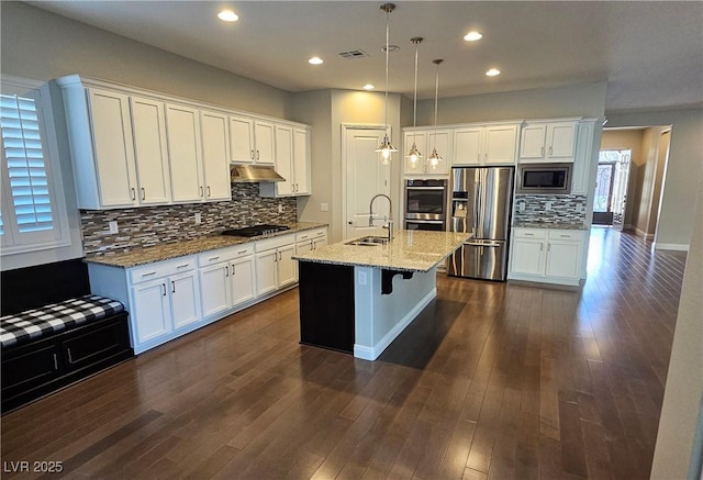 kitchen featuring stainless steel appliances, dark wood-type flooring, white cabinetry, a sink, and under cabinet range hood