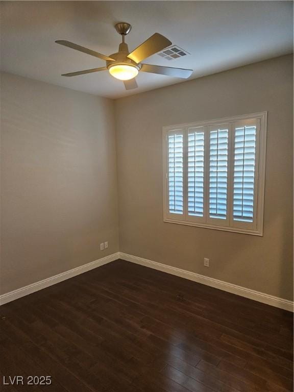 empty room featuring ceiling fan, dark wood-style flooring, visible vents, and baseboards