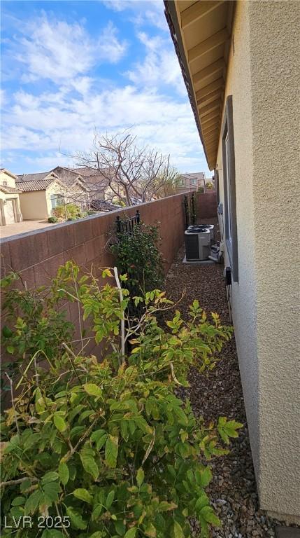 view of yard featuring central AC unit and fence