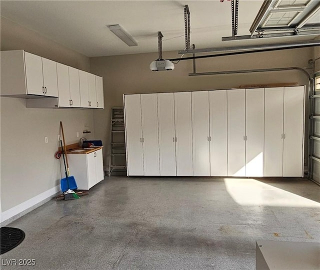 garage featuring a garage door opener and baseboards