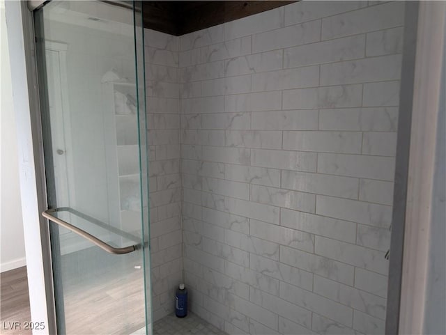 bathroom featuring a shower stall and wood finished floors