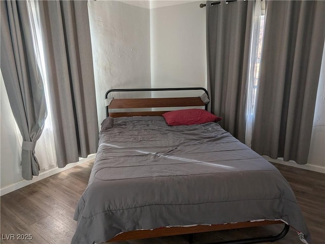 bedroom featuring baseboards and wood finished floors