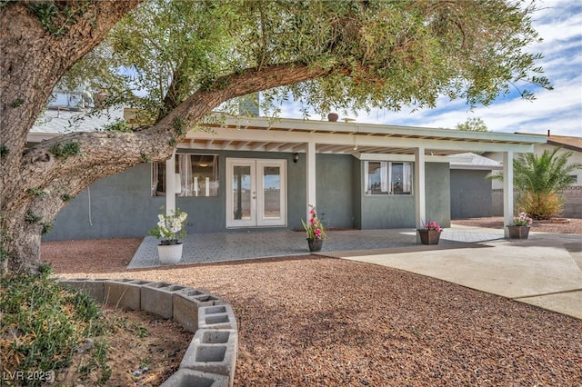 ranch-style home featuring stucco siding, a patio area, and french doors