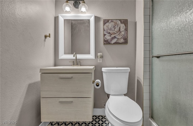 full bath with toilet, a textured wall, an enclosed shower, and vanity