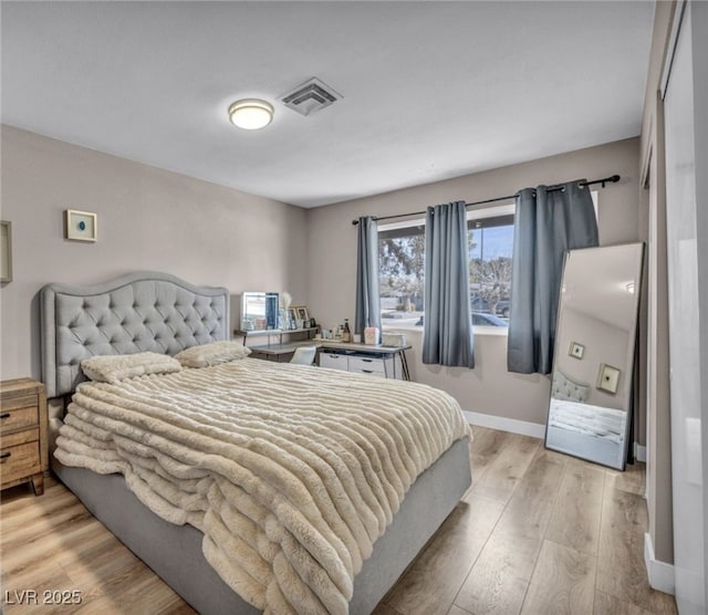 bedroom featuring light wood-type flooring, visible vents, and baseboards