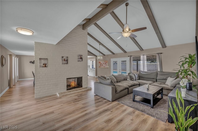 living area featuring french doors, a fireplace, light wood finished floors, high vaulted ceiling, and beamed ceiling