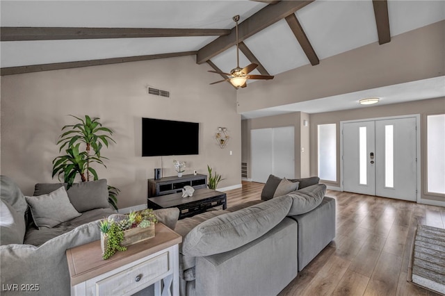 living area featuring french doors, visible vents, wood finished floors, high vaulted ceiling, and beamed ceiling