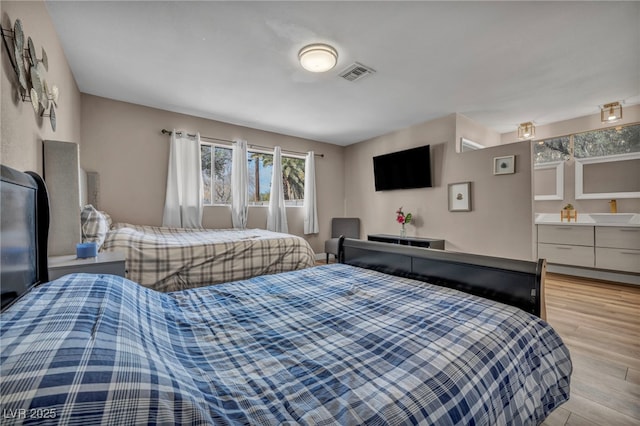 bedroom with light wood-type flooring and visible vents