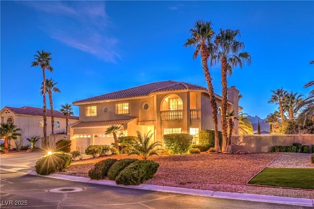 mediterranean / spanish-style house featuring stucco siding, concrete driveway, and a tile roof