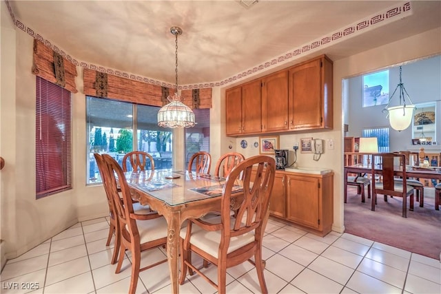 dining area featuring light tile patterned floors, light colored carpet, and an inviting chandelier