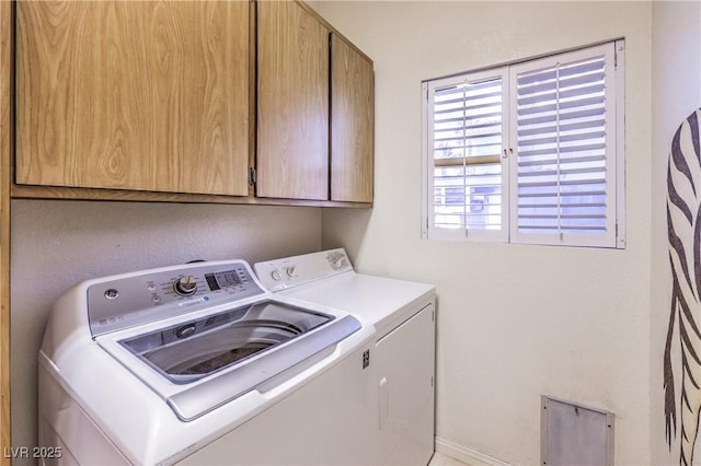 clothes washing area featuring cabinet space and washing machine and clothes dryer