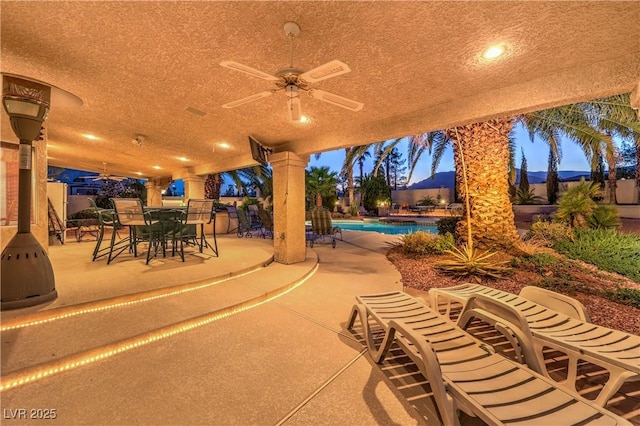 view of patio / terrace with a fenced in pool and a ceiling fan