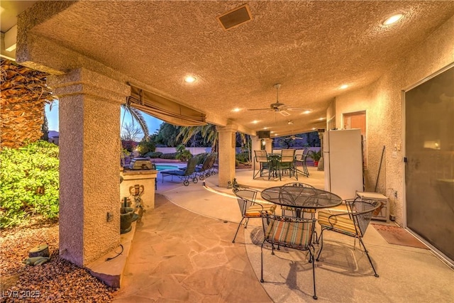 view of patio / terrace featuring outdoor dining space, a ceiling fan, and an outdoor pool