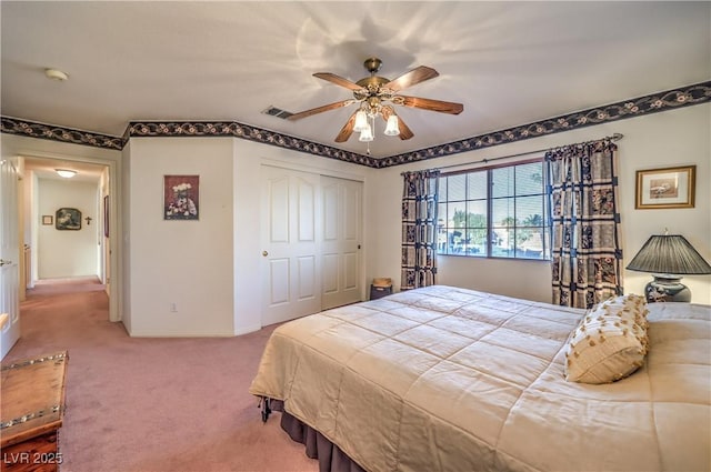 carpeted bedroom with a closet, baseboards, visible vents, and ceiling fan