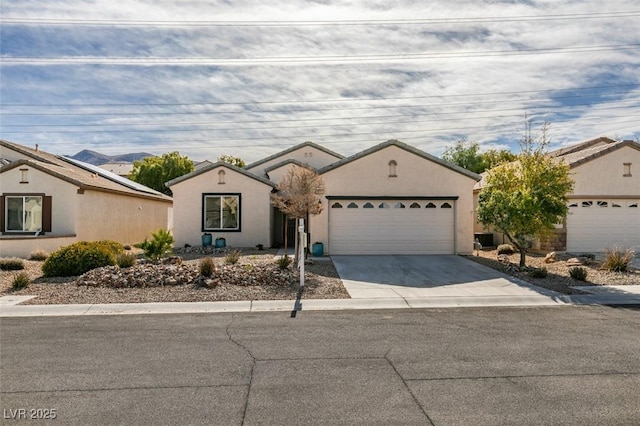 ranch-style house featuring stucco siding, an attached garage, and driveway