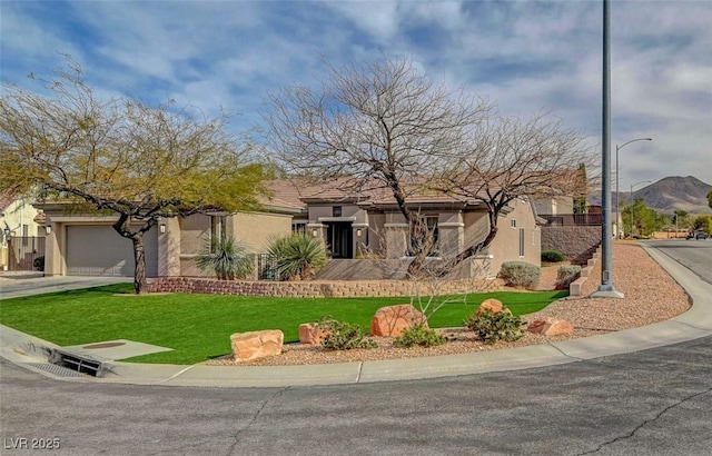 view of front of house with a garage, driveway, a front lawn, and stucco siding