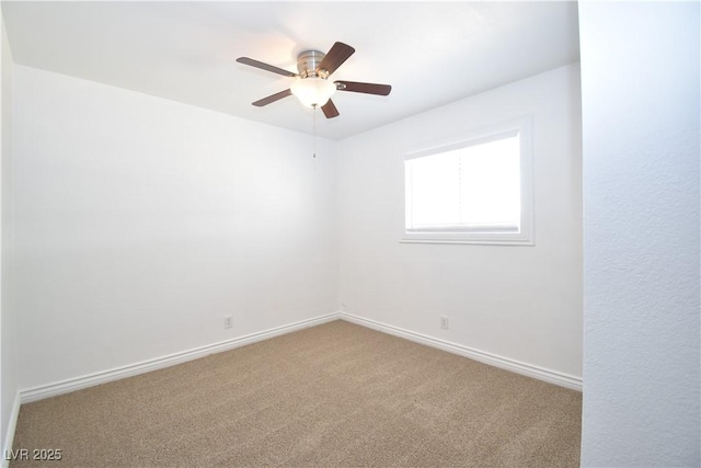 spare room with ceiling fan, carpet, and baseboards