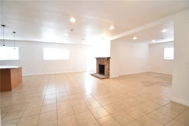 basement featuring a fireplace, baseboards, a wealth of natural light, and recessed lighting